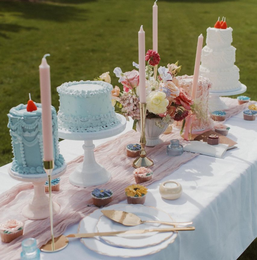 Beautiful display of multiple custom celebration cakes at an outdoor event
